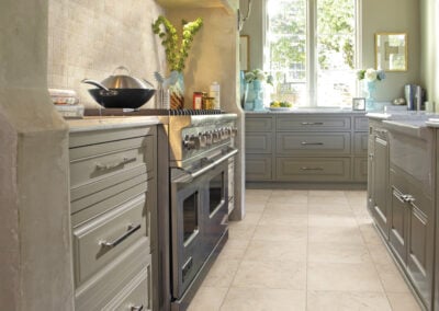 Modern kitchen featuring slab countertops, gray cabinetry, and tile flooring, showcasing a bright and inviting space ideal for home renovations.
